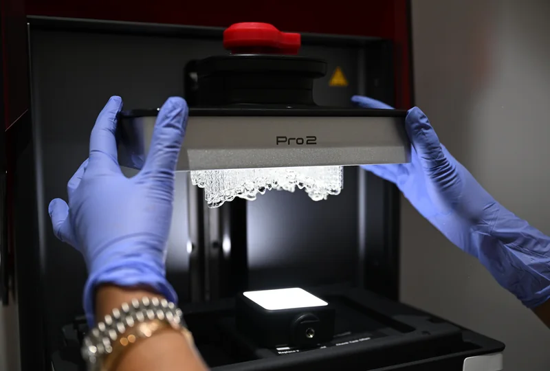Freshly printed restorations lifted out of the SprintRay Pro 2 printer in the Smile Spot digital lab