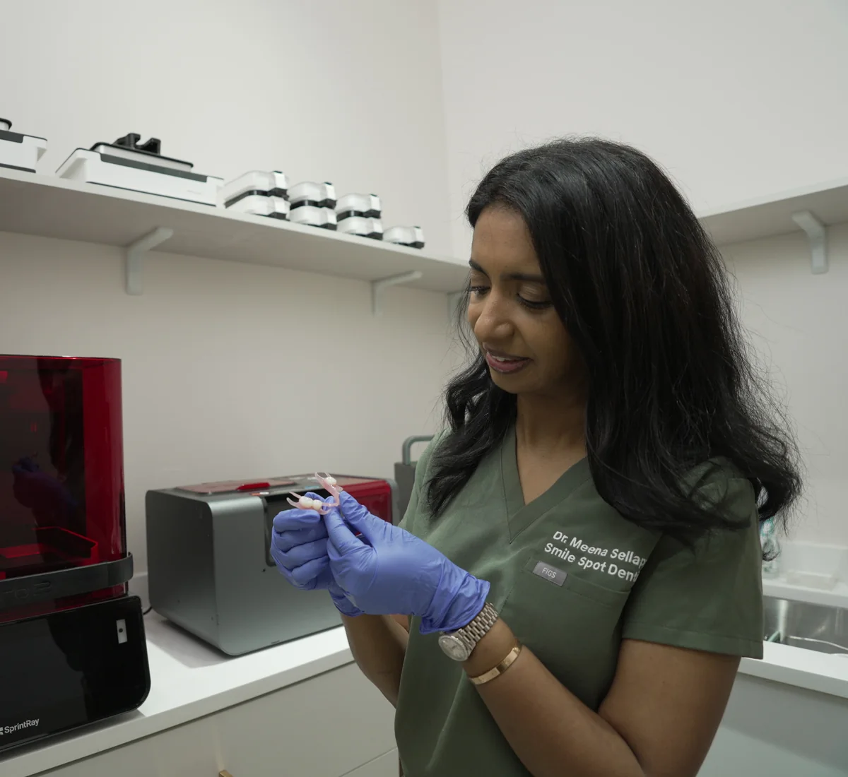 Dr. Sellappan holding an in-office printed restoration beside the SprintRay printer at Smile Spot Dentistry, Venice FL