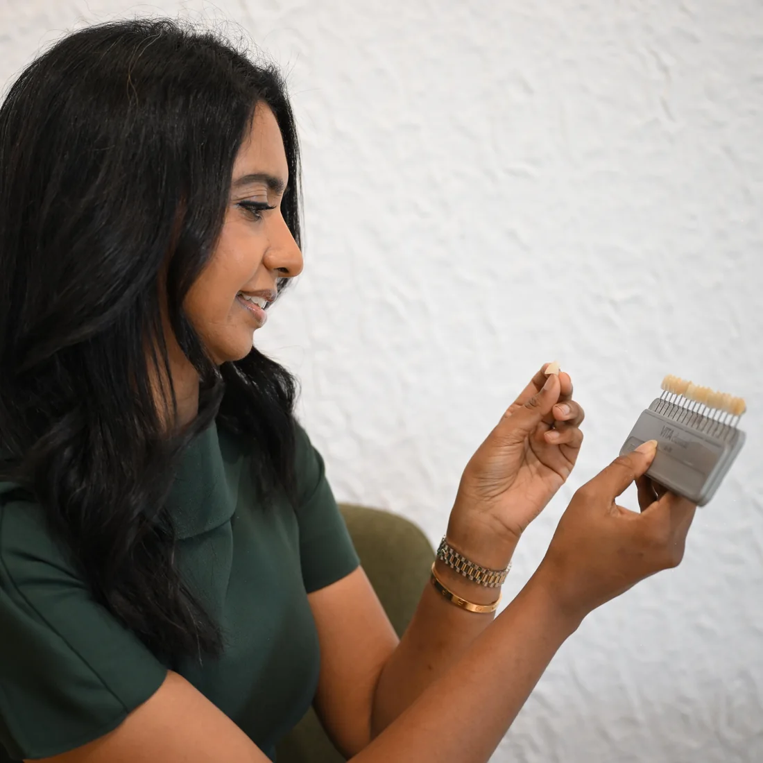 Dr. Sellappan matching a ceramic crown to a shade guide at Smile Spot Dentistry, Venice, Florida